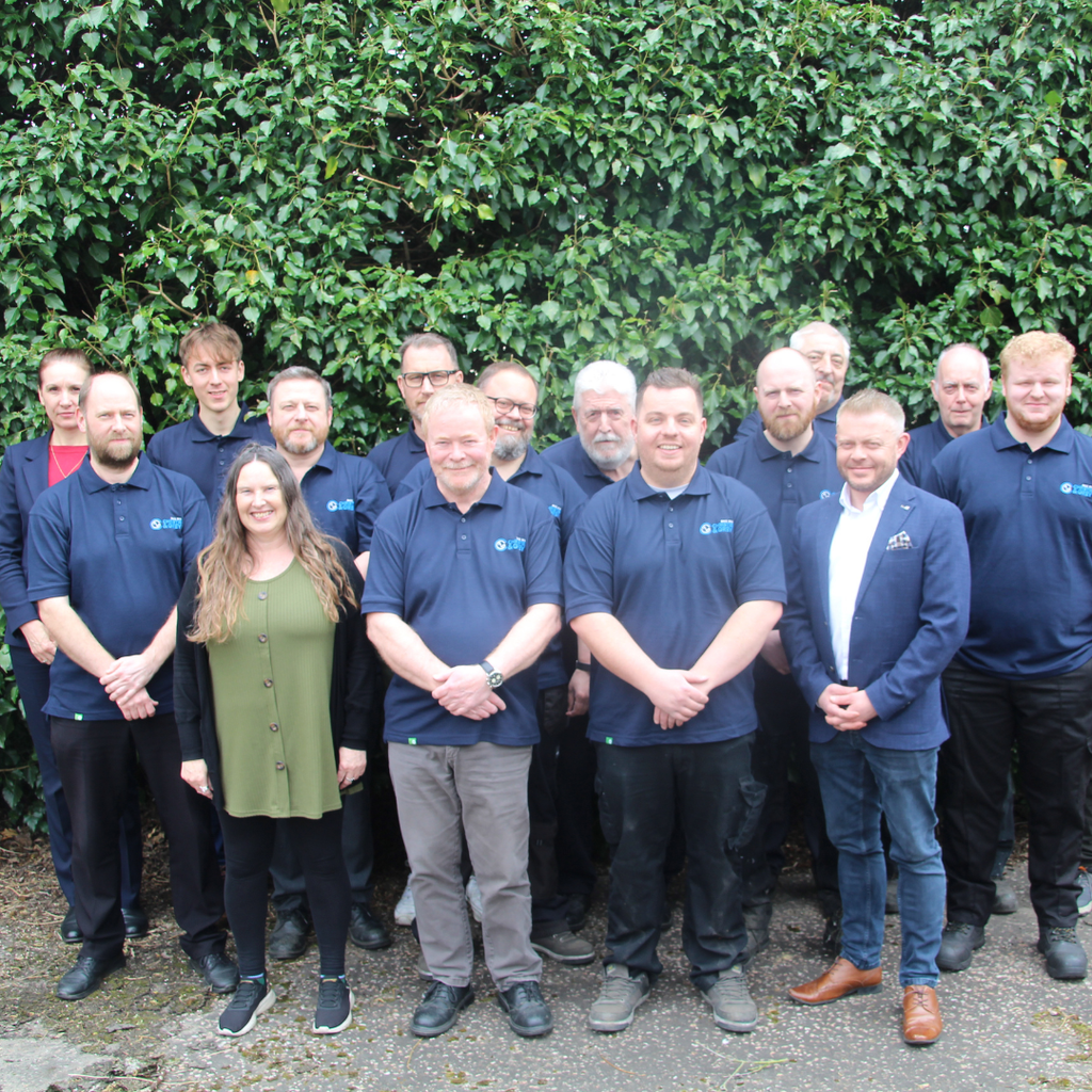 The Christie & Grey team wearing branded polos and smiling at the camera